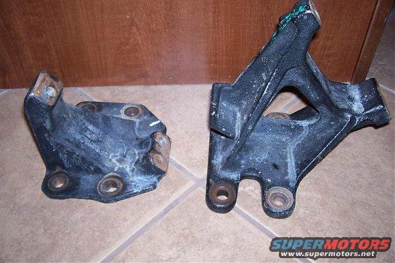 Two black metal engine mounts on a tiled floor