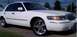 2001 Mercury Grand Marquis - A white 2001 Mercury Grand Marquis is shown from the front three-quarter view, custom wheels and red brake calipers.