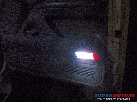 Interior door panel with illuminated lights and speaker grille