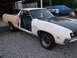 1971 Ford Ranchero - Ford Ranchero in primer and white paint, driver door ajar. Another vehicle is covered in the background.