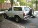 1993 Ford Bronco - A white 1993 Ford Bronco is parked next to a building, with a spare tire mounted on the rear.