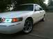 2001 Mercury Grand Marquis - White 2001 Mercury Grand Marquis sedan with custom wheels shown from the front quarter angle.