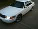 2001 Mercury Grand Marquis - A white 2001 Mercury Grand Marquis sedan is parked on a concrete surface, showing its front and side profile.
