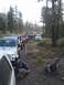 1994 Ford Bronco - A convoy of off-road vehicles travels down a wooded dirt path, with one person attending to a tire.