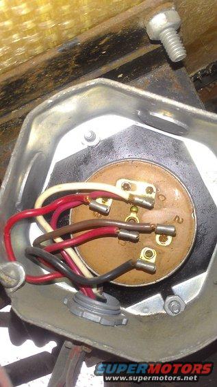 Close-up of an electrical connector with multiple colored wires attached to terminals inside a metal housing