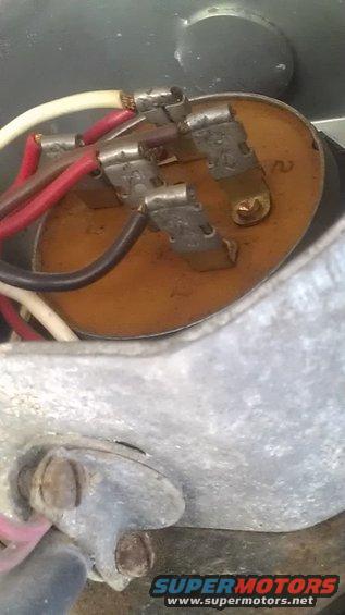 Electrical connector with red, black, and white wires attached to a circular brown component