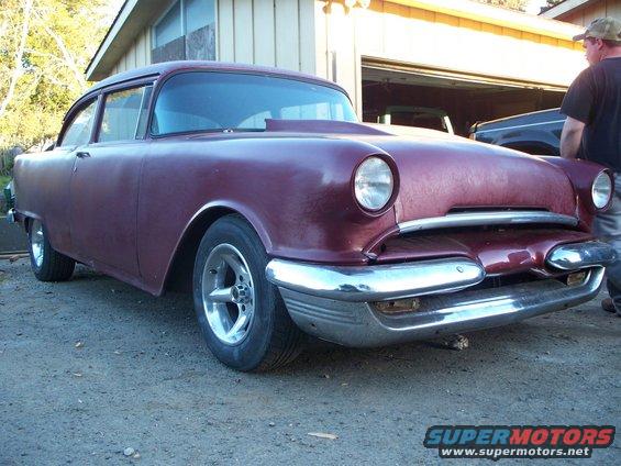 Maroon sedan with hood scoop and chrome bumper