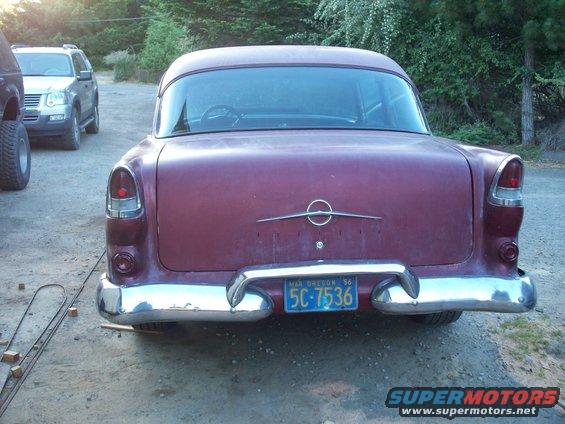Maroon sedan with a chrome bumper and a blue license plate reading 5C-7536. Another SUV is parked behind it