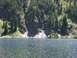 1996 Ford Bronco - A lake scene with a duck swimming, backed by a densely forested mountain slope with patches of snow.