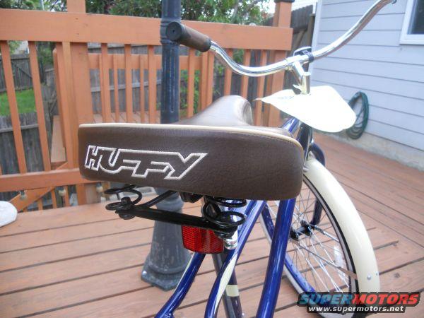 Blue bicycle with brown HUFFY seat and chrome handlebars