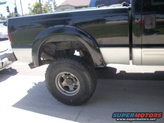 2001 Ford F-250 pickup truck, black over silver, side view, showing rear fender flare and wheel