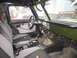 1974 Ford Bronco - The interior of a vehicle shows custom modifications including gauges and a roll cage.