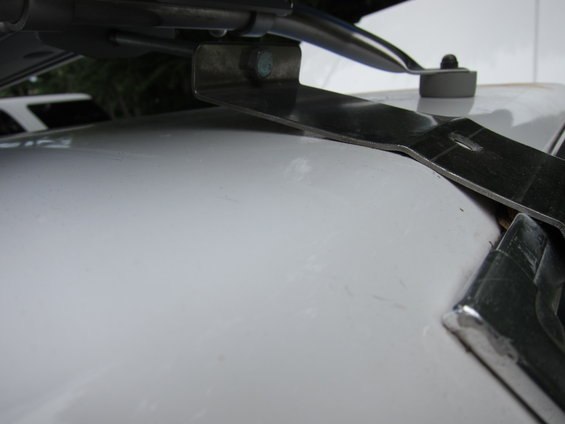 Close-up of a metal bracket attached to a white surface, with chrome trim visible