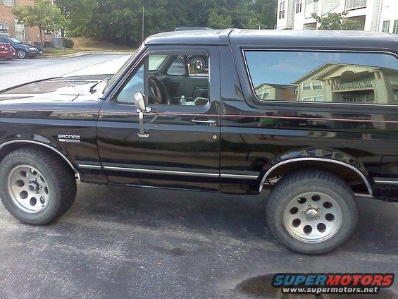 Black Ford Bronco side view, showing the driver's side door and rear quarter panel