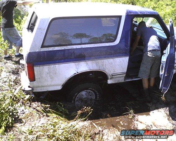 1996 Ford Bronco stuck in mud with people around it