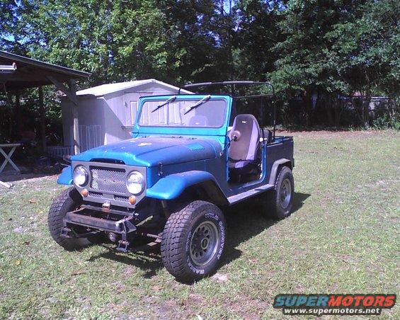 1969 Toyota Land Cruiser FJ40 parked on grass, blue paint, open doors, aftermarket bumper
