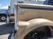 1959 Kenworth W900A - Close-up of a tan truck's fender and door, showing the number '57' emblem and a partial view of another truck and RV in the background.