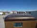 1959 Kenworth W900A - View from the top of a brown truck cab, showing the roof and a side window. Other trucks are visible in the background at a farm.