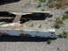 1959 Kenworth W900A - A section of a heavily rusted truck frame lies on the ground, showing signs of wear and tear.