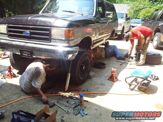 1989 Ford Bronco front view with mechanics working underneath