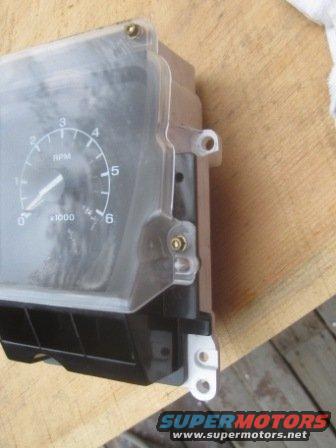 Gauge cluster with RPM and speed indicators, clear plastic cover, black housing, and mounting brackets