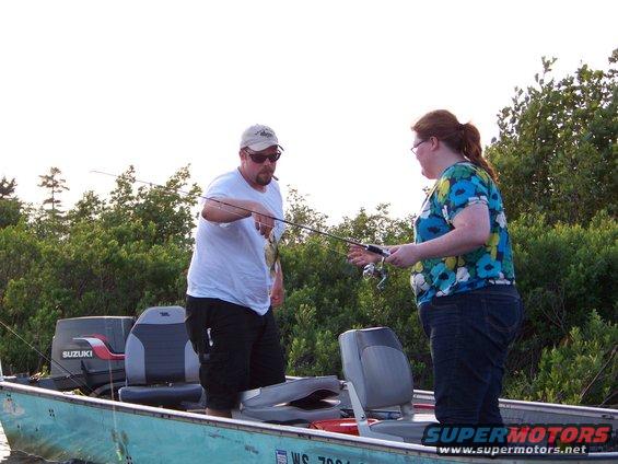 Two people fishing from a boat with a Suzuki outboard motor