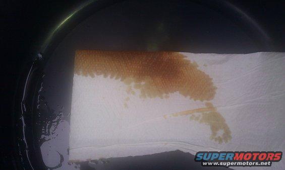Transmission fluid stain on a paper towel, with a Supermotors.net logo in the corner