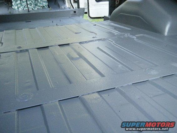Gray van floor with ribbed panels and metal inserts