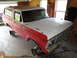 1978 Ford Bronco - A red and white 1978 Ford Bronco is shown in a garage, missing its wheels and undergoing restoration.