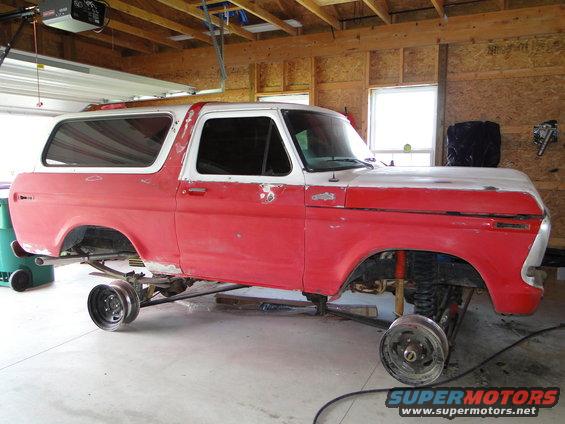 1978 Ford Bronco on jack stands, red and white paint, wheels off
