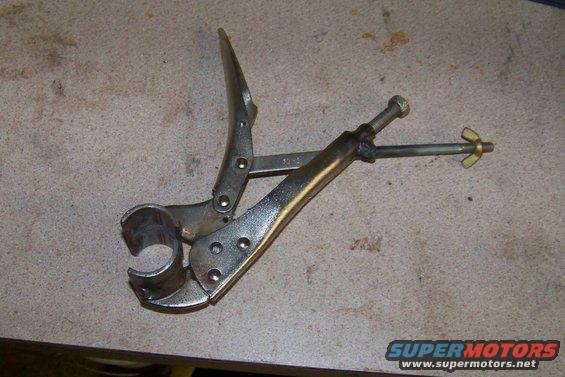 Locking pliers with pipe clamp attachment on workbench