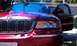 1999 Mercury Grand Marquis - Front view of a red Mercury Grand Marquis with its driver's door ajar.
