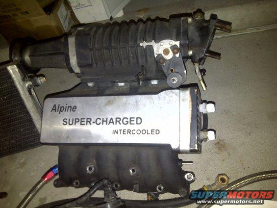 Alpine super-charged intercooled assembly with black ribbed supercharger and silver intercooler plate