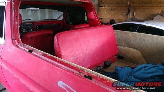 1978 Ford Bronco interior showing red seats and door panels, with a tan carpeted cargo area