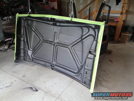 Underside of a car hood, taped for painting
