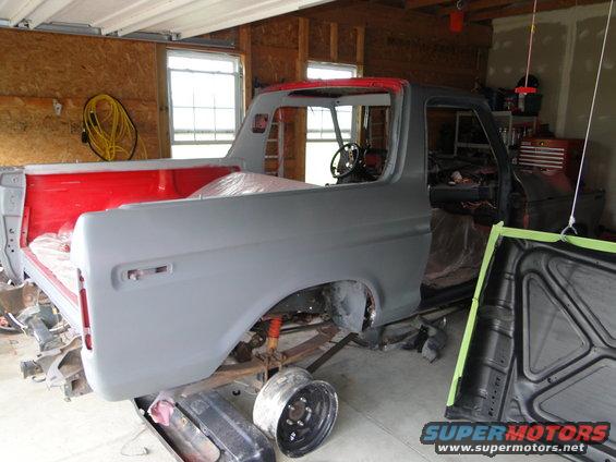 1978 Ford Bronco body in primer, undergoing restoration in a garage