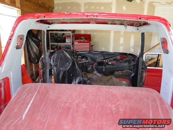 Red vehicle interior with dashboard exposed and covered seats