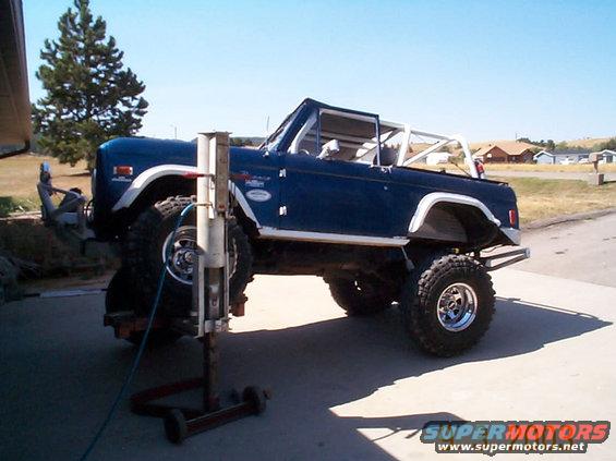 Blue 1977 Ford Bronco with roll cage, lifted on large tires