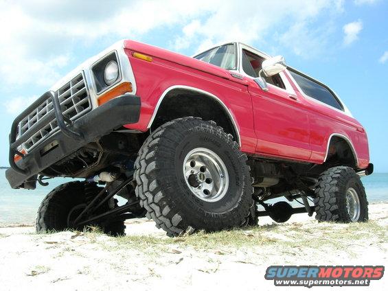 1978 Ford Bronco with lifted suspension and large tires on a sandy beach