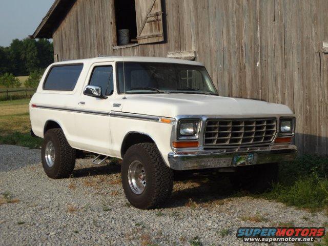 White 1978 Ford Bronco parked in front of a wooden barn