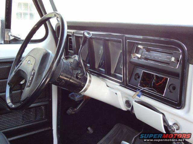 Interior shot of a vehicle's dashboard, showing the steering wheel, radio, and climate controls