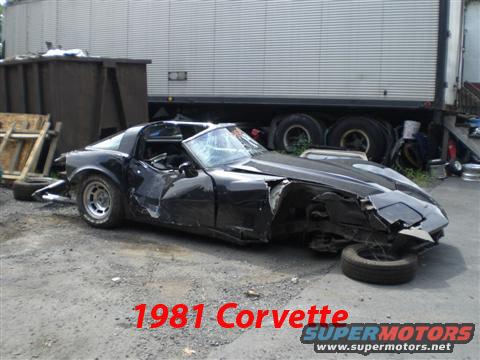 Damaged black 1981 Chevrolet Corvette with a caved-in front end and shattered windshield, viewed from the front three-quarter angle