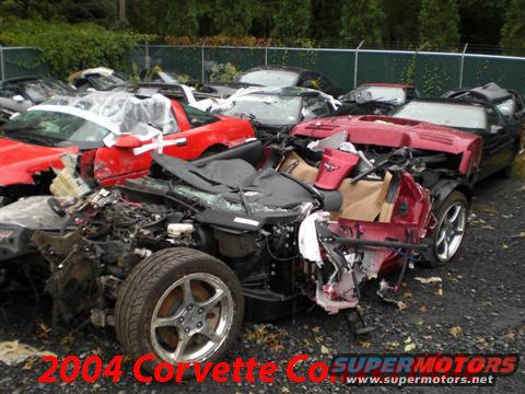 Wrecked red Corvette, front view. Text overlay reads '2004 Corvette'