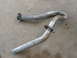 1984 Ford Bronco - Two bent exhaust pipes are shown on a concrete surface.