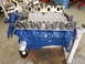 1967 Ford Mustang - A blue Ford V8 engine block is shown with its valve covers and an attached oil filter, resting on an engine stand.