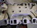 1967 Ford Mustang - An aluminum intake manifold is shown from a top-down perspective, with visible ports and fasteners.