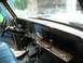 1978 Ford F-250 - The interior of a 1978 Ford F-250 shows a brown dashboard and an open glove compartment, with a blue seat visible.