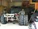 1983 Chevrolet C/K Pickup - A man measures a large tire next to a custom truck chassis that has been fitted with oversized tractor tires.