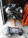 2004 Ford Crown Victoria - Engine and transmission assembly displayed on engine stands in a garage.