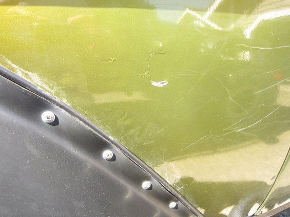 Green fender flare with visible screws and scratches
